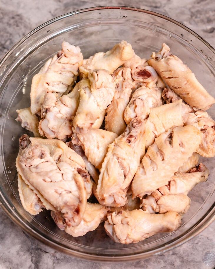Drain the water and transfer the chicken wings to a large mixing bowl.