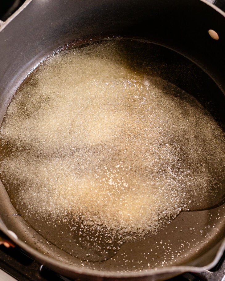 Heat oil in a medium to deep pot. Spread the sugar evenly across the bottom.
