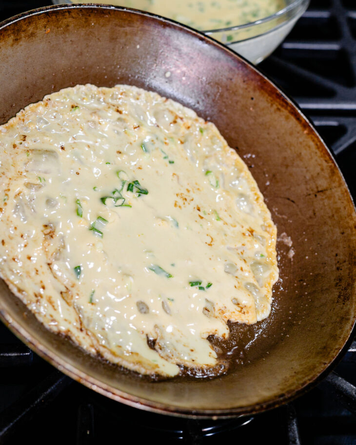 Immediately swirl the pan to let the batter spread into a thin, even layer.