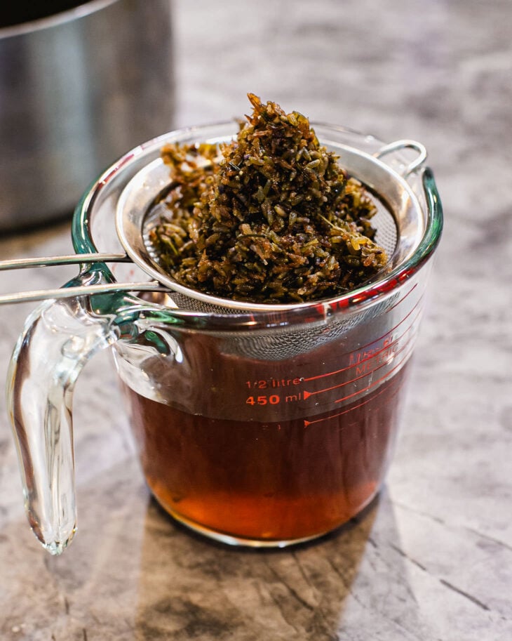 Gently press on the lavender with the back of a spoon to extract every last drop of syrup.
