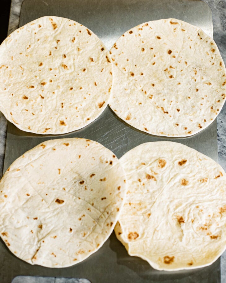 4 piece of tortillas laid out on a work surface.