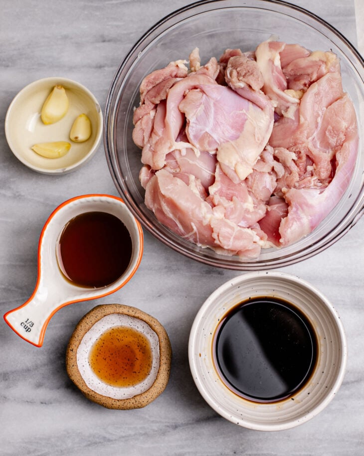 A list of ingredients for Asian grilled chicken - chicken thighs, coconut aminos, shaoxing wing, honey.