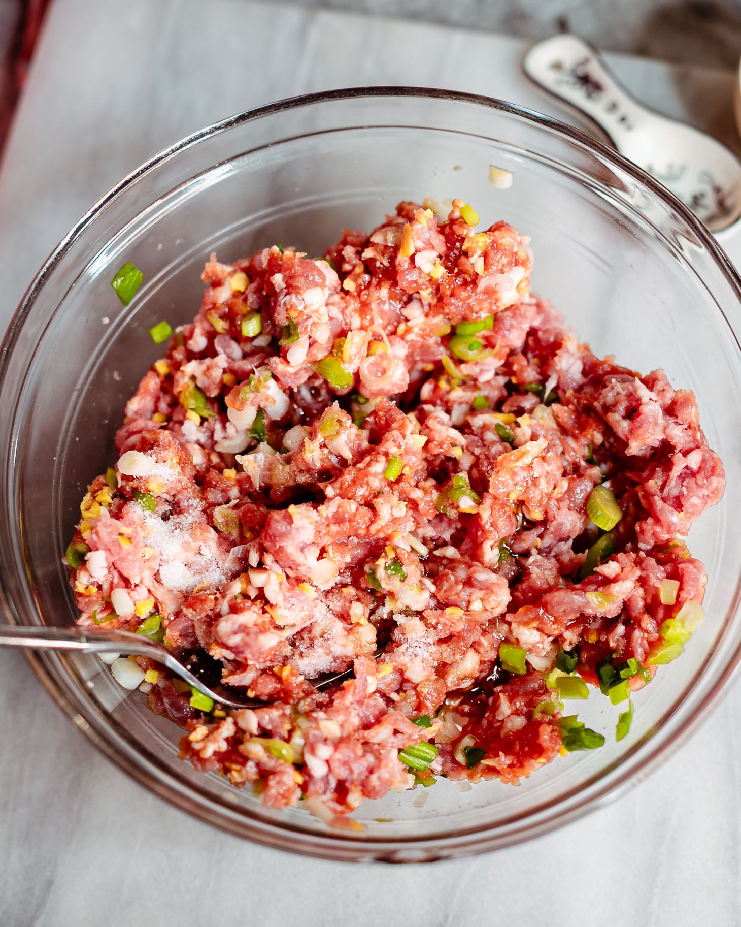 Ground pork combined with ginger, green onions, coconut aminos, Shaoxing wine, sesame oil, and salt before mixing into a juicy dumpling filling.
