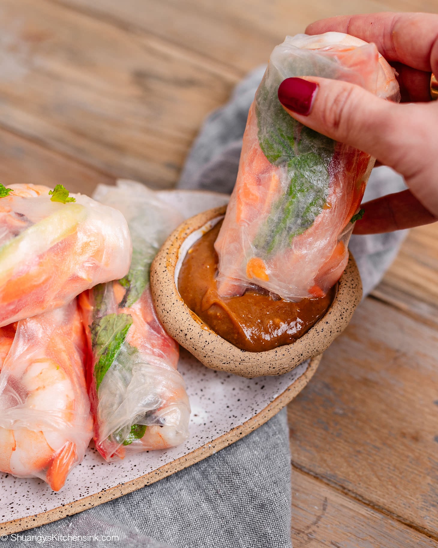 Fresh shrimp spring roll dipped into creamy peanut dipping sauce, filled with juicy shrimp, cucumbers, carrots, red bell peppers, and fresh mint wrapped in tender rice paper.