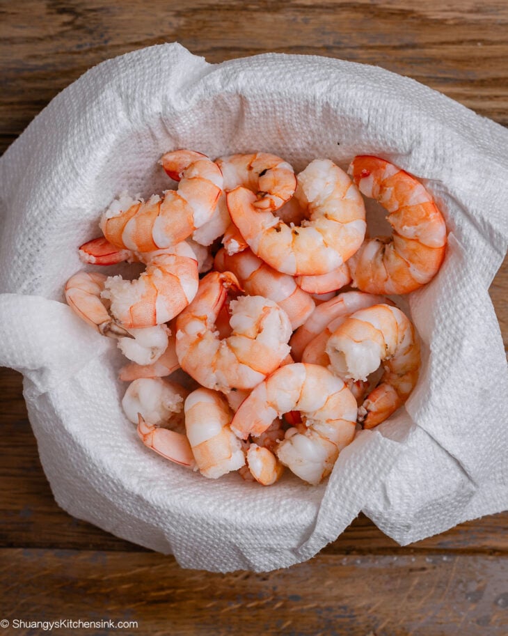 Shrimp are draining on a piece of paper towel.