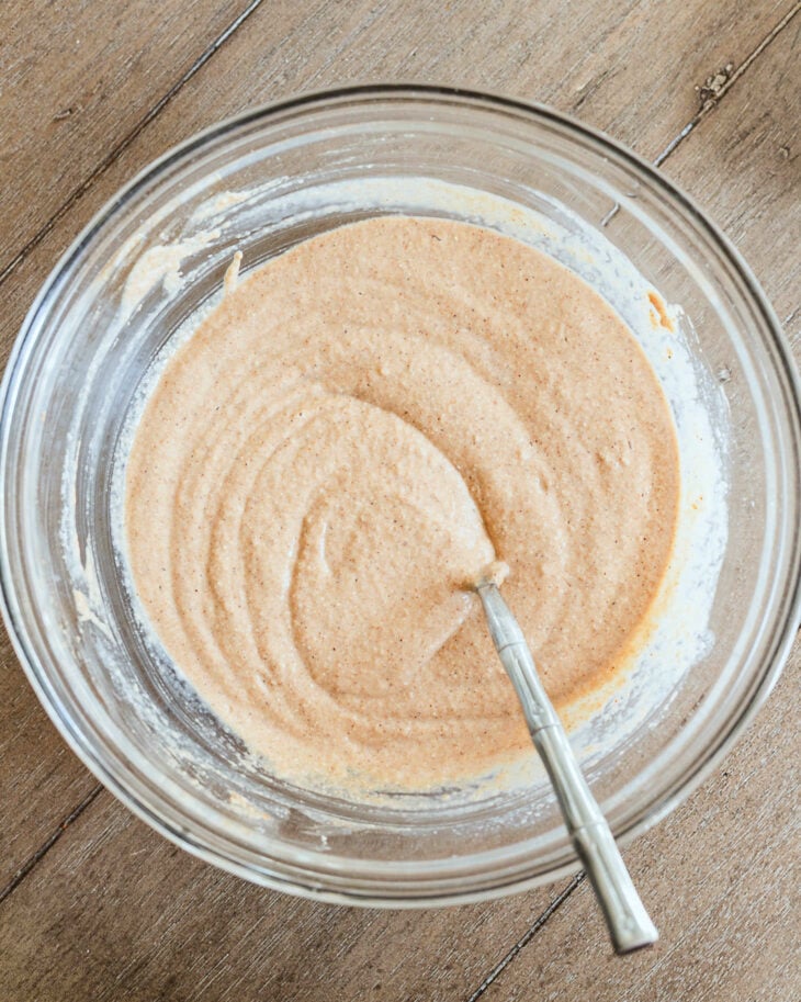 Thick apple butter pancake batter in a glass bowl