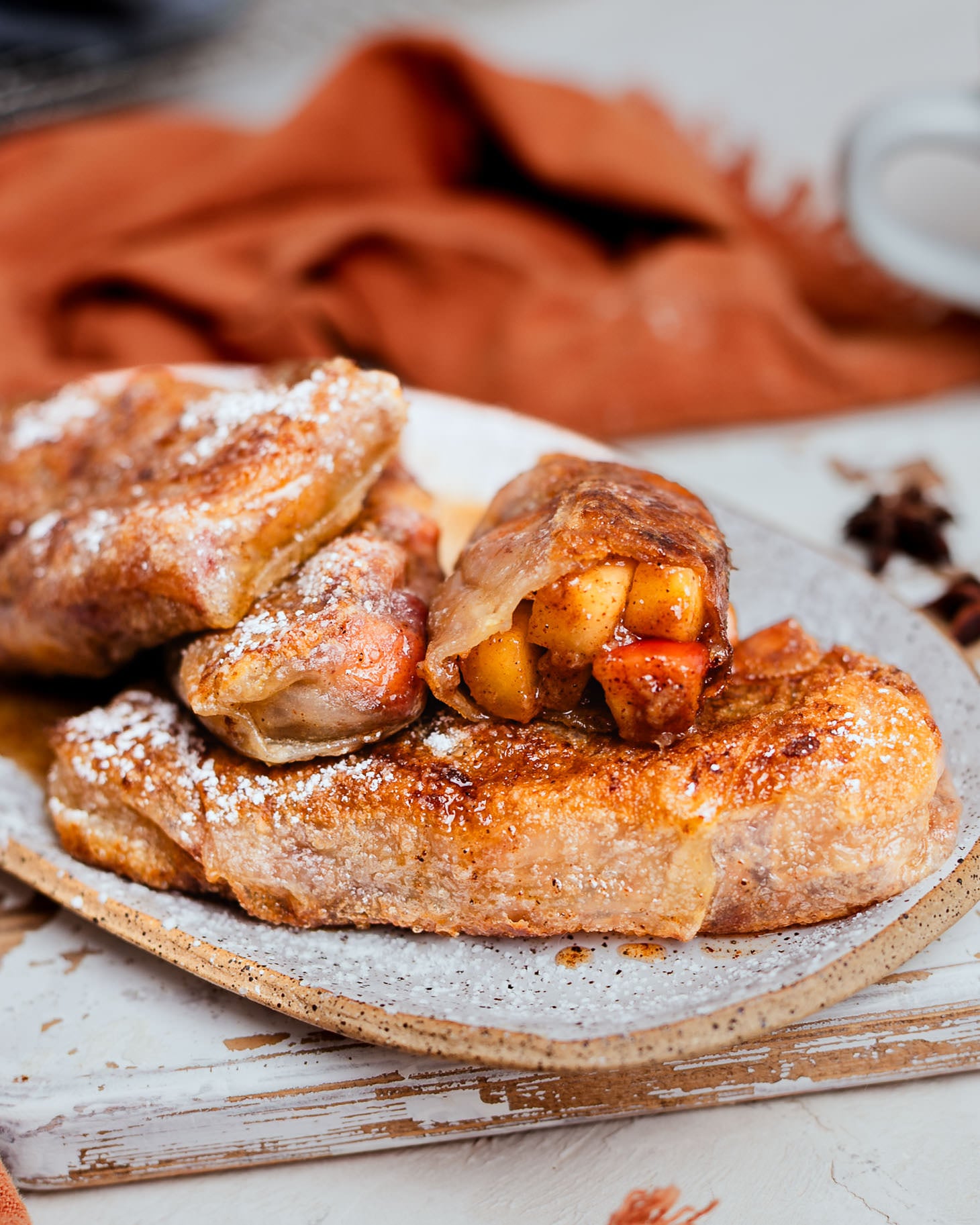 Crispy golden apple pie spring rolls on a plate