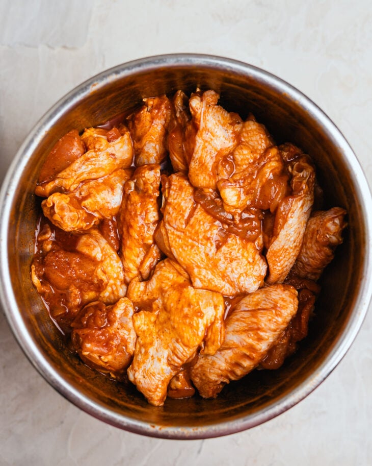 Chicken wings tossed in honey soy marinade in a bowl