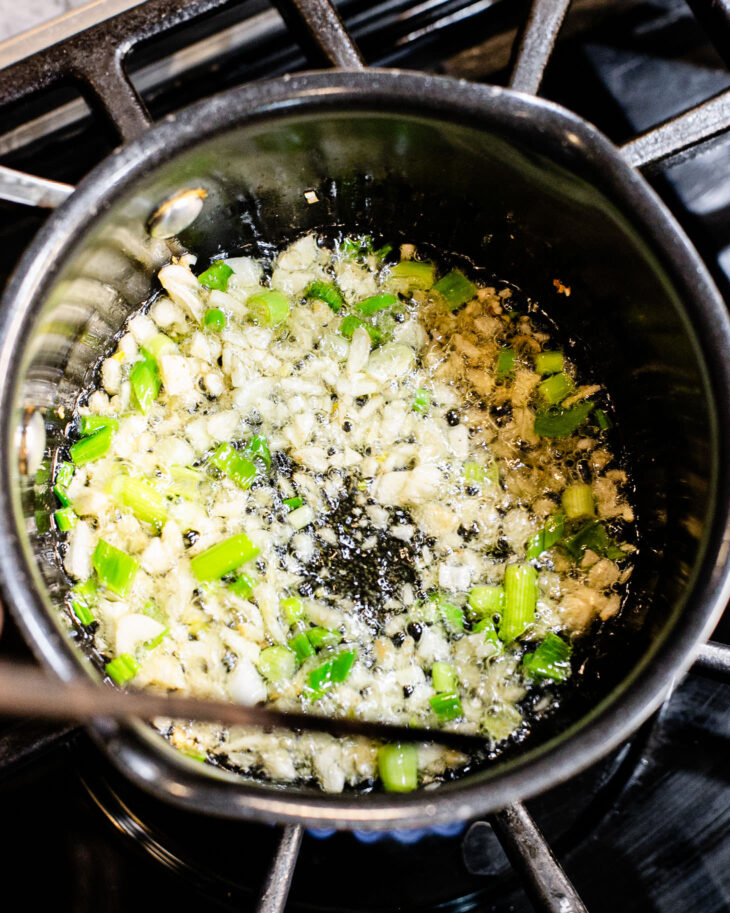 Minced garlic and green onion sizzling in oil