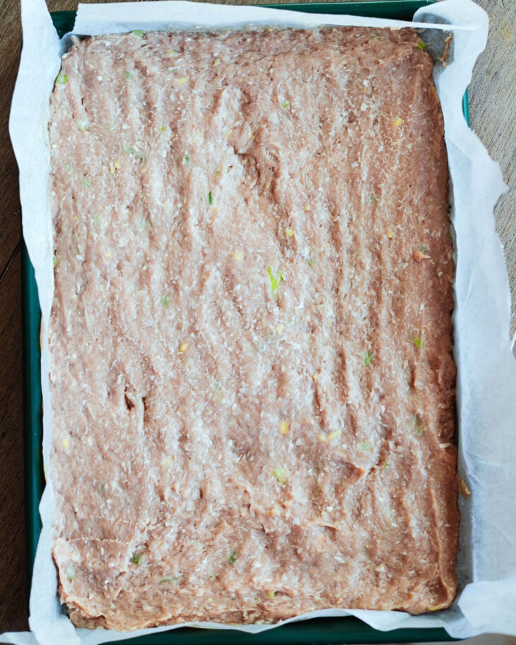 Dumpling filling pressed into a thin layer on a parchment lined sheet pan